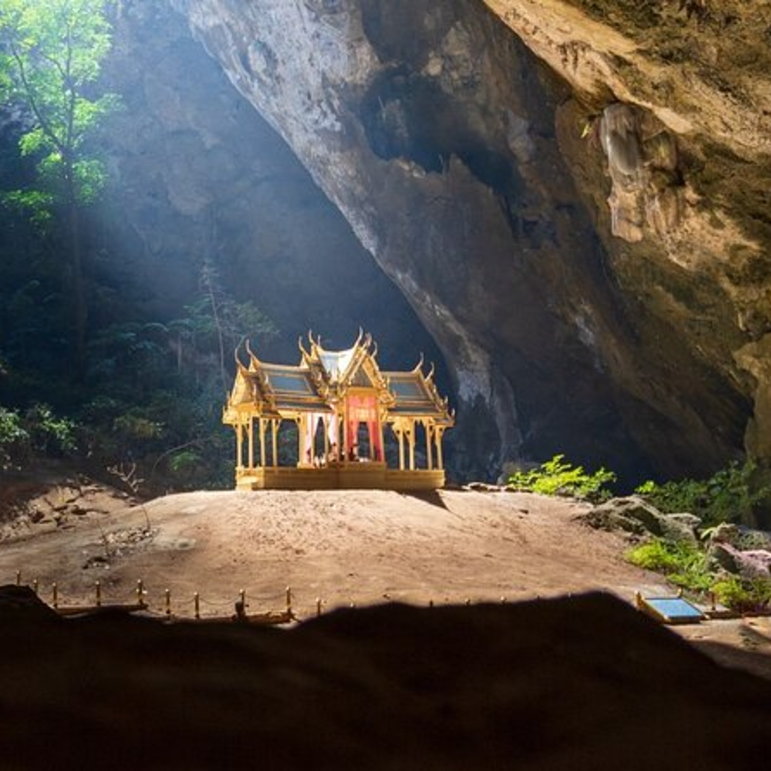 The golden Kuha Karuhas Pavilion lit by sunlight inside Phraya Nakhon Cave near Lyndale Lodge