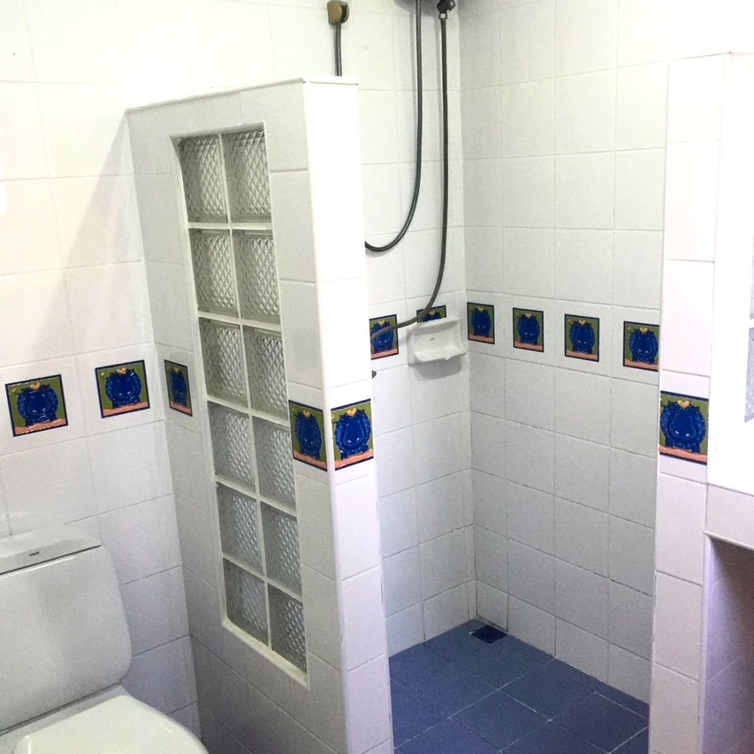 The clean, white-tiled bathroom of the Standard Double Room at Lyndale Lodge with a walk-in shower