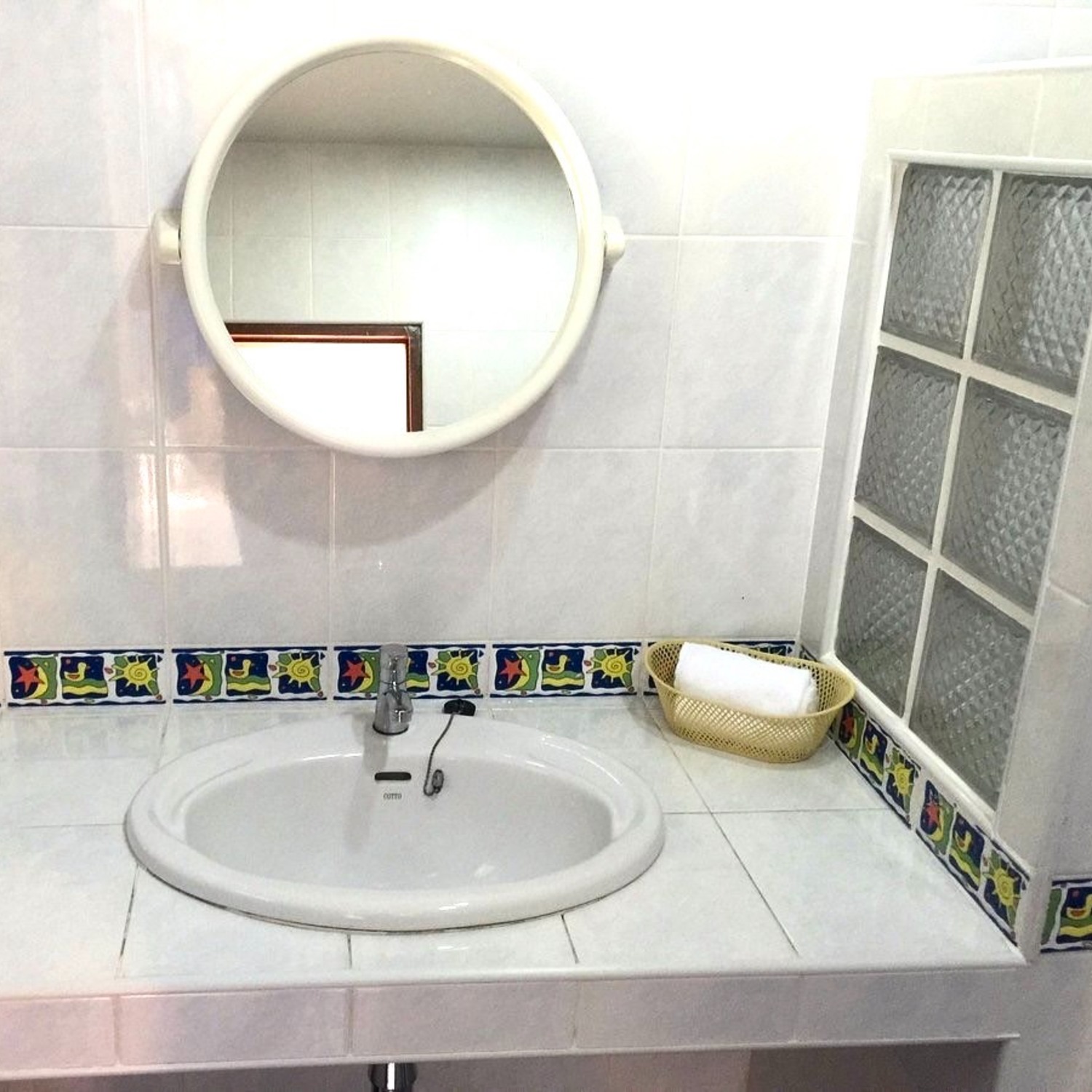 The vanity with round mirror, basin and fresh towels in the Standard Double Room bathroom at Lyndale Lodge
